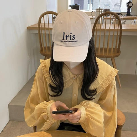 muguetの「iris logo cap」をかぶる女性