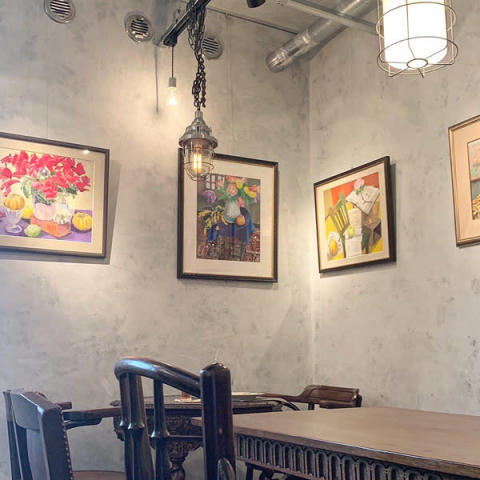 下北沢に新しくオープンしたカフェ「CAL COFFEE CLUB」の絵画が飾られた内装。