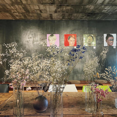 アート空間で楽しむことができる北千住にある「BUoY cafe」のアート作品が壁に飾られた店内